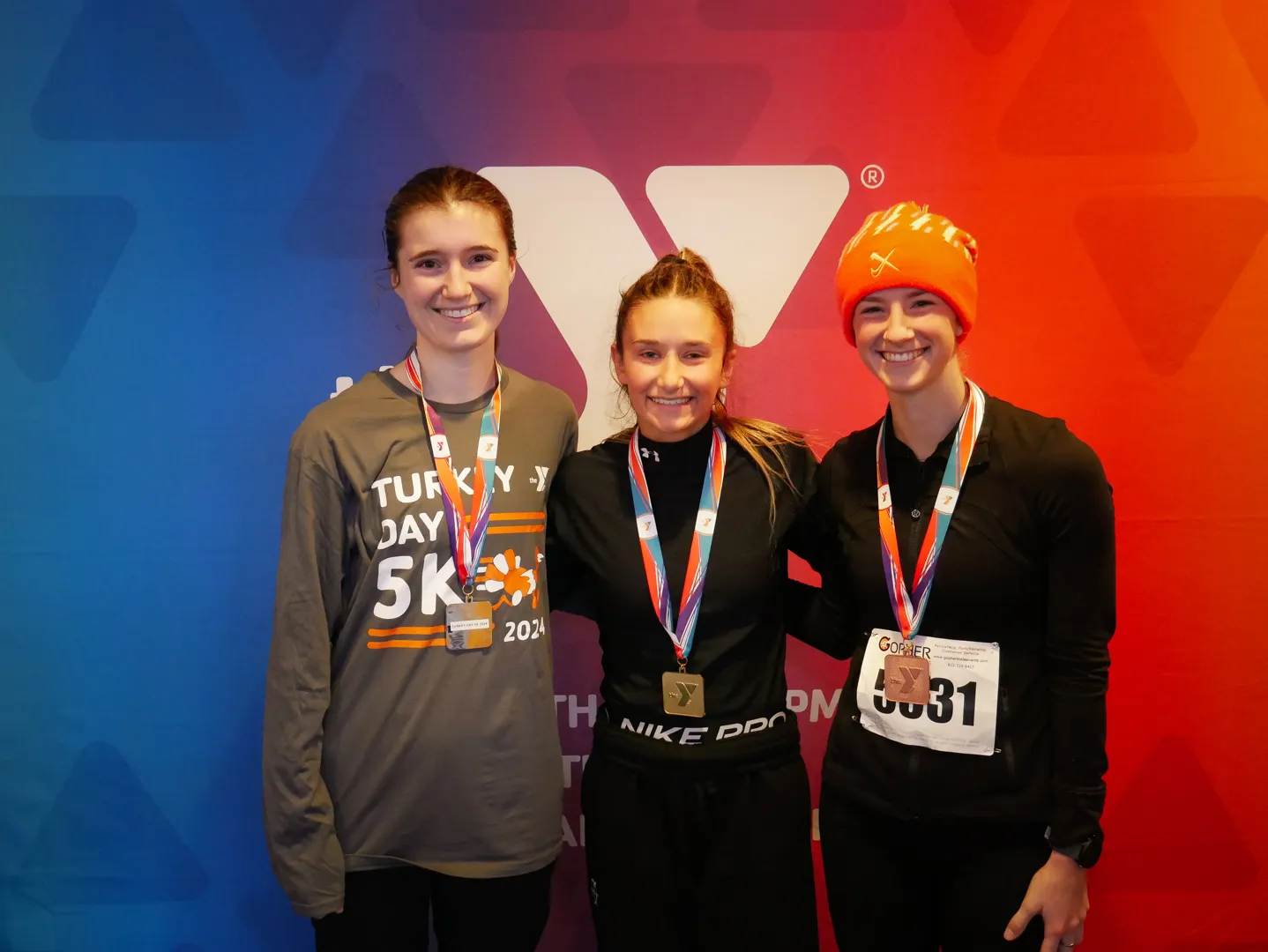 3 race winners smiling at the camera