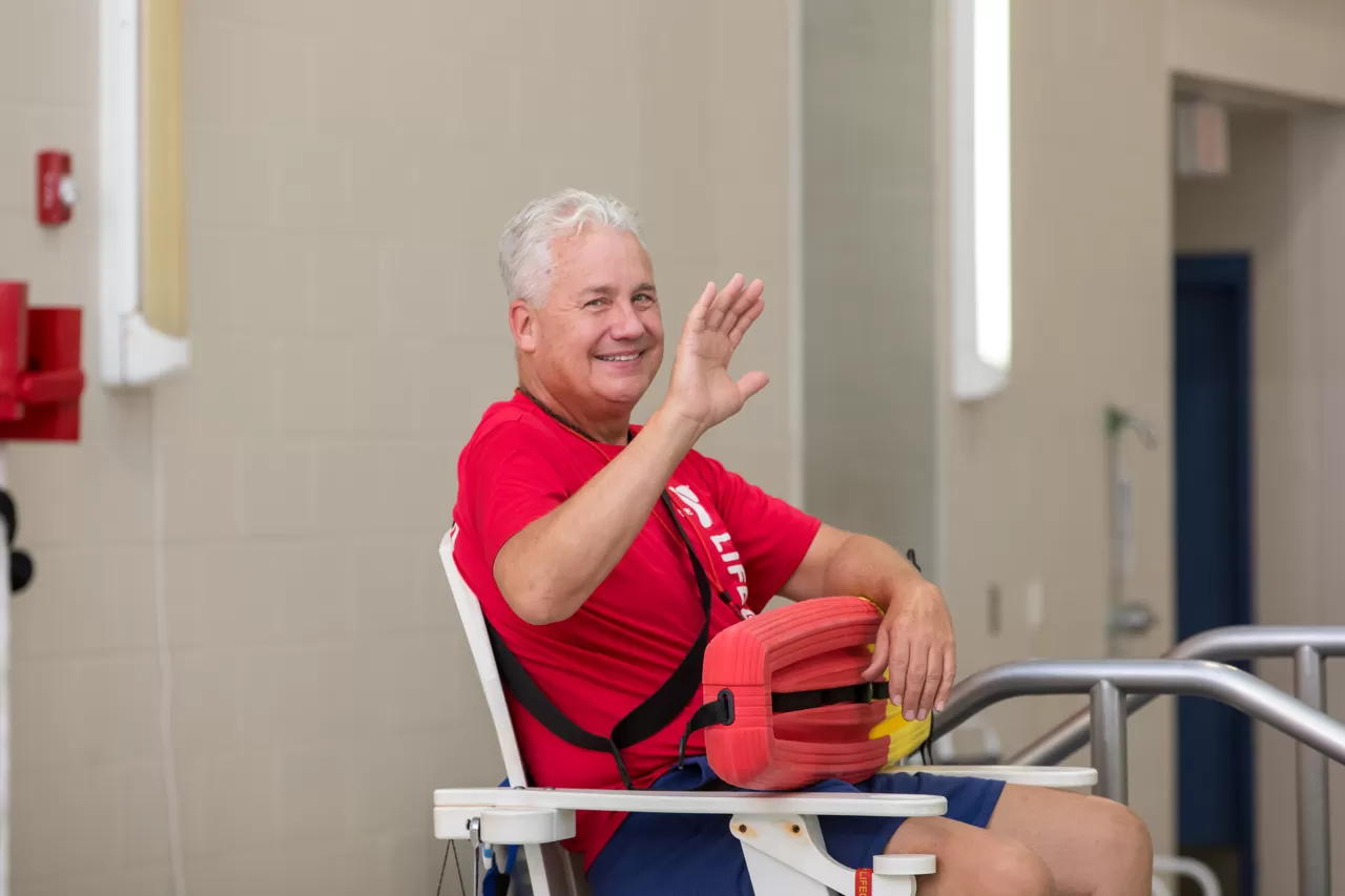 a lifeguard smiling and waving