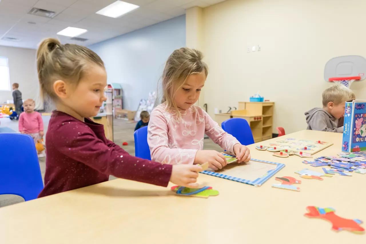 two girls working on a puzzle together