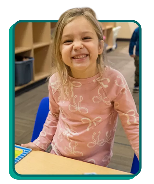 girl smiling in a YMCA Child Care classroom
