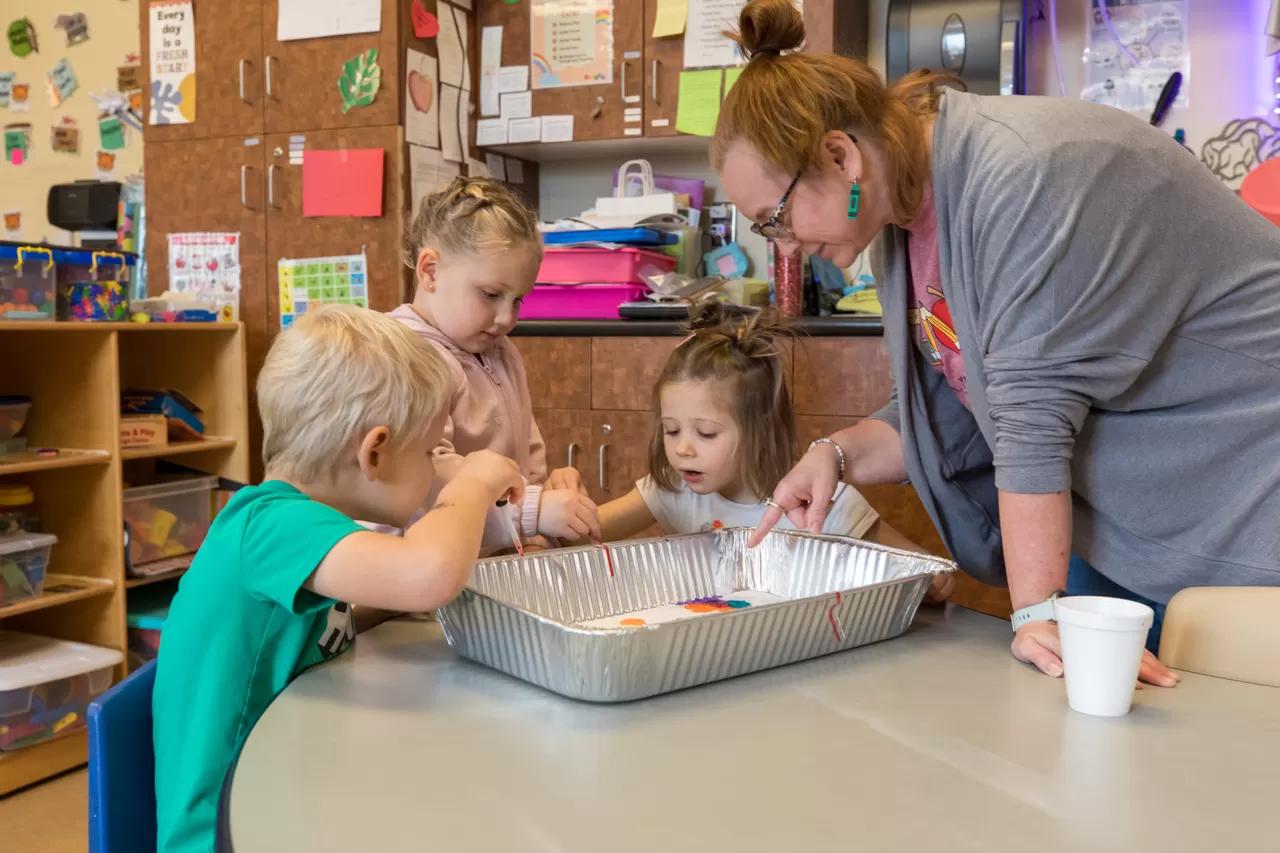 Children and child care leader doing a STEM project