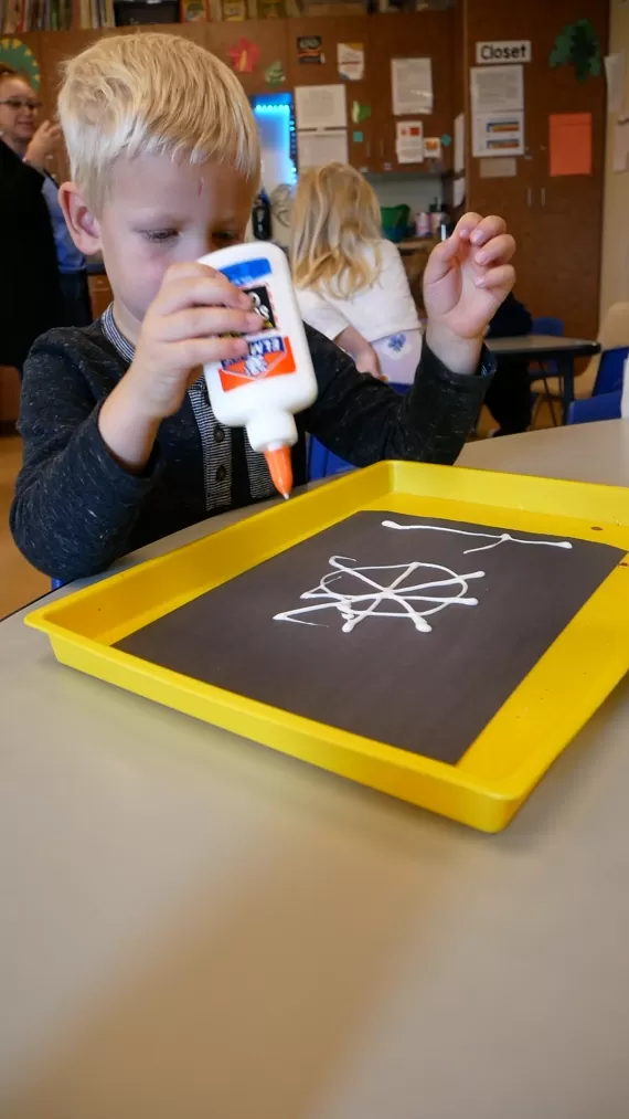 Child using glue and making a craft