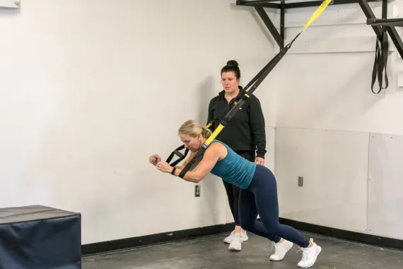 personal trainer helping with TRX