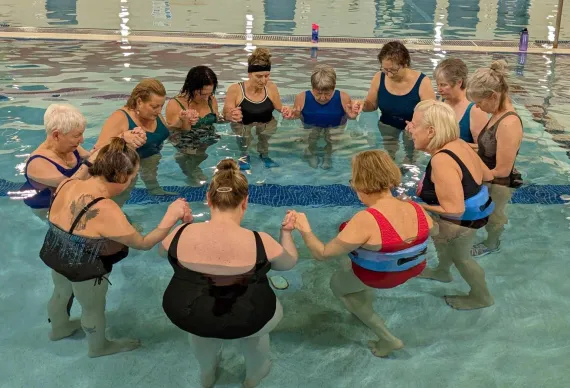 water aerobics class praying together