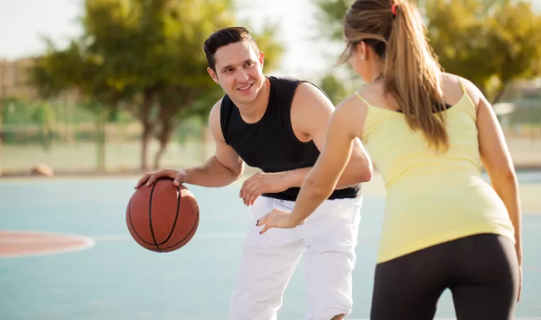 mand and woman playing basketball