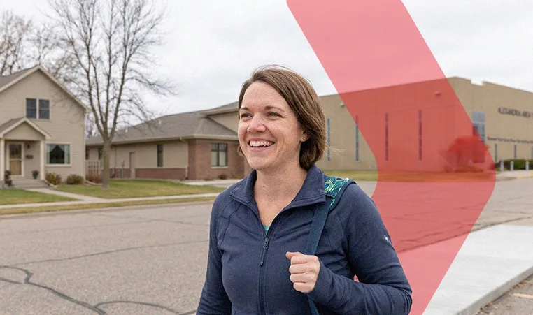 woman walking outside with a gym bag