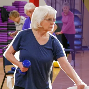 senior woman lifting dumbbells in a group class