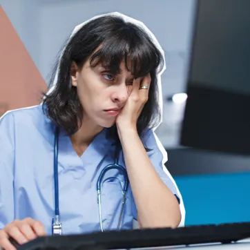 tired woman using a desktop computer