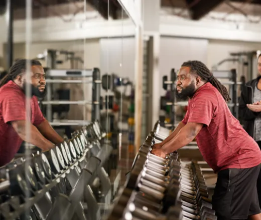 man grabbing dumbbells off of a weight rack